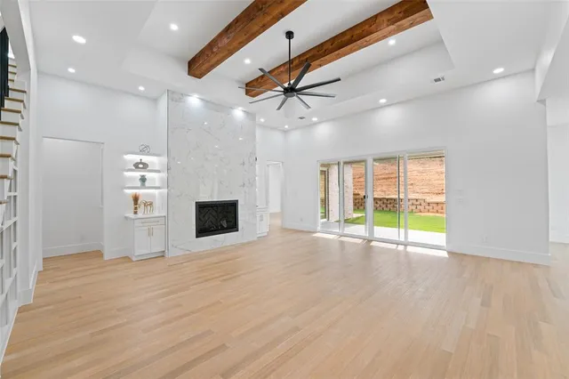 a view of an empty room with a fireplace and a window