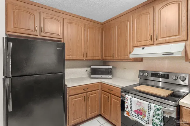 a kitchen with stainless steel appliances granite countertop a refrigerator a stove a sink and cabinets