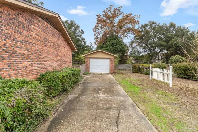 a front view of a house with a garden and trees
