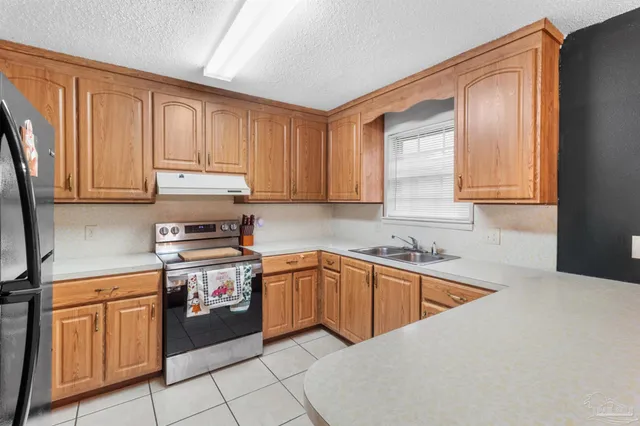 a kitchen with stainless steel appliances granite countertop a sink stove and cabinets