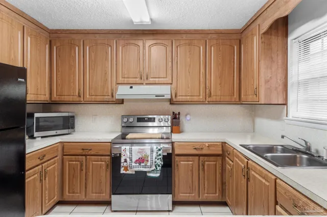 a kitchen with stainless steel appliances granite countertop a sink a stove and cabinets