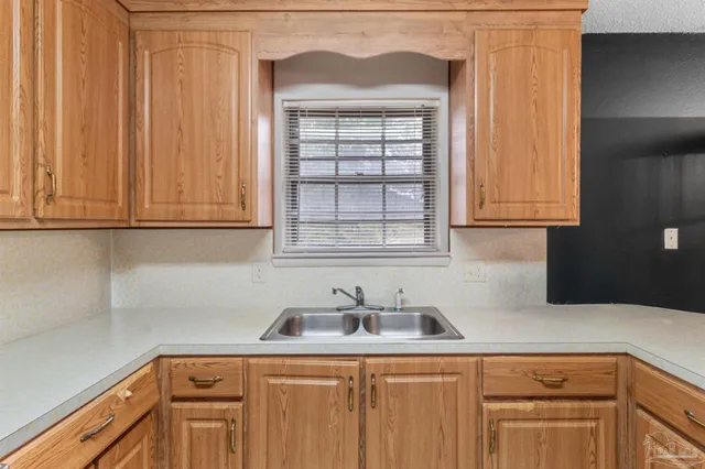 a kitchen with stainless steel appliances granite countertop white cabinets and a sink