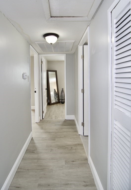 160 Laurelton Street Springfield, MA 01109 - Photo 14 of 30 a view of a hallway with wooden floor and a bathroom