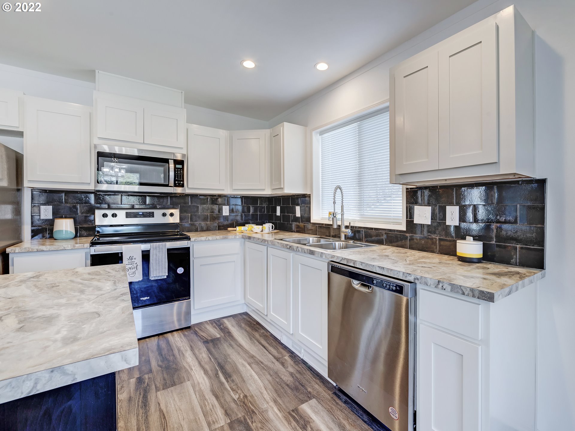 4671 Union Terrace Springfield, OR 97478 - Photo 6 of 18 a kitchen with granite countertop a stove top oven a sink dishwasher and white cabinets with wooden floor