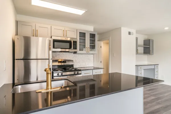 a kitchen with stainless steel appliances granite countertop a refrigerator a stove a microwave and a refrigerator