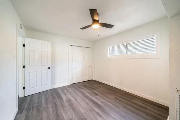 a view of empty room with wooden floor