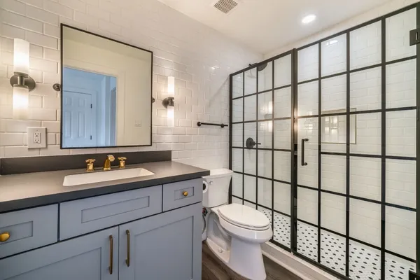 a bathroom with a toilet sink shower and mirror