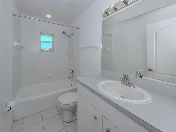 a bathroom with a granite countertop sink a toilet and bathtub