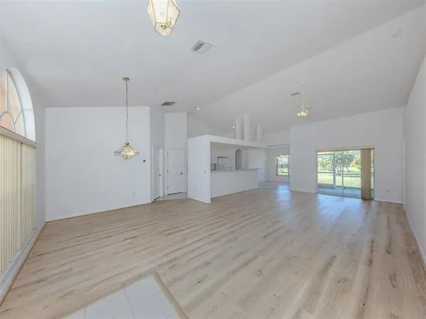 a view of empty room with wooden floor and window