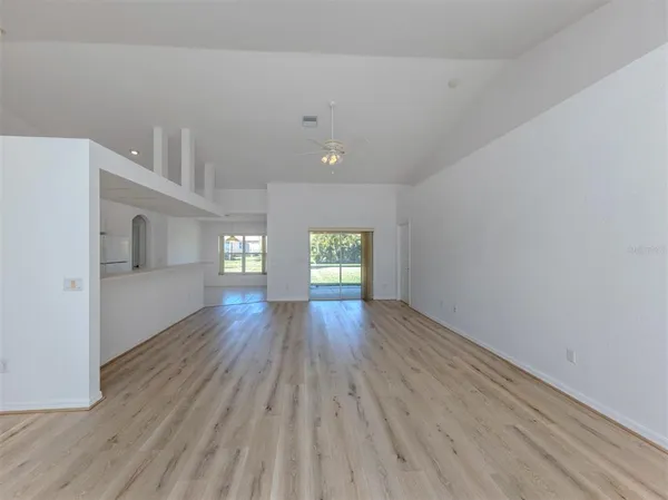 a view of empty room with wooden floor and window