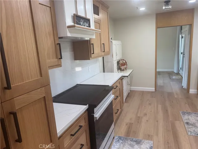 a kitchen with sink a refrigerator and wooden floor