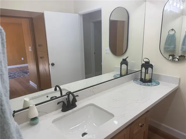 a bathroom with a double vanity sink a vanity and a mirror
