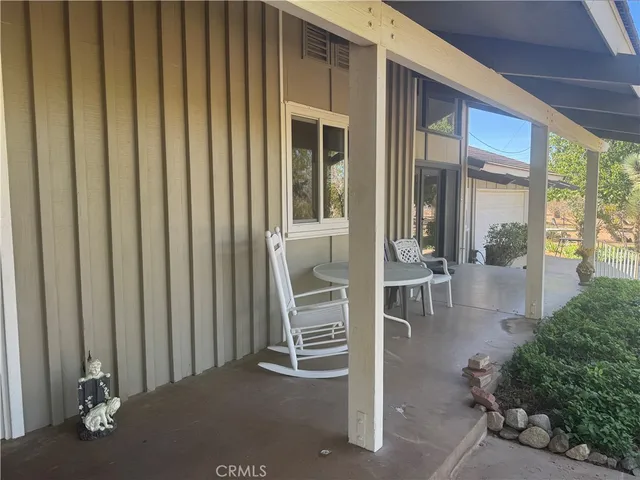 a view of a porch with a table and chairs