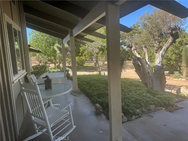 a view of balcony with furniture and garden