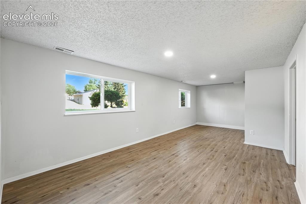 7033 Sequoyah Way Colorado Springs, CO 80915 - Photo 5 of 20 a view of an empty room with wooden floor and a window