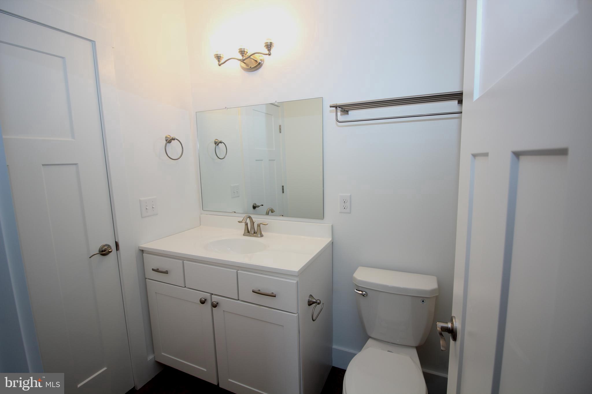 306 Main Street Dover, DE 19901 - Photo 11 of 33 a bathroom with a toilet a sink and mirror
