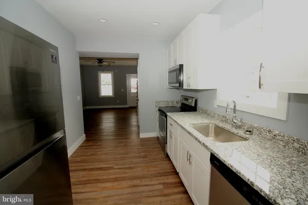 a hallway with sink and wooden floor