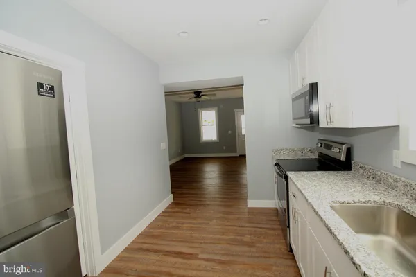 a kitchen with granite countertop a sink and a stove top oven