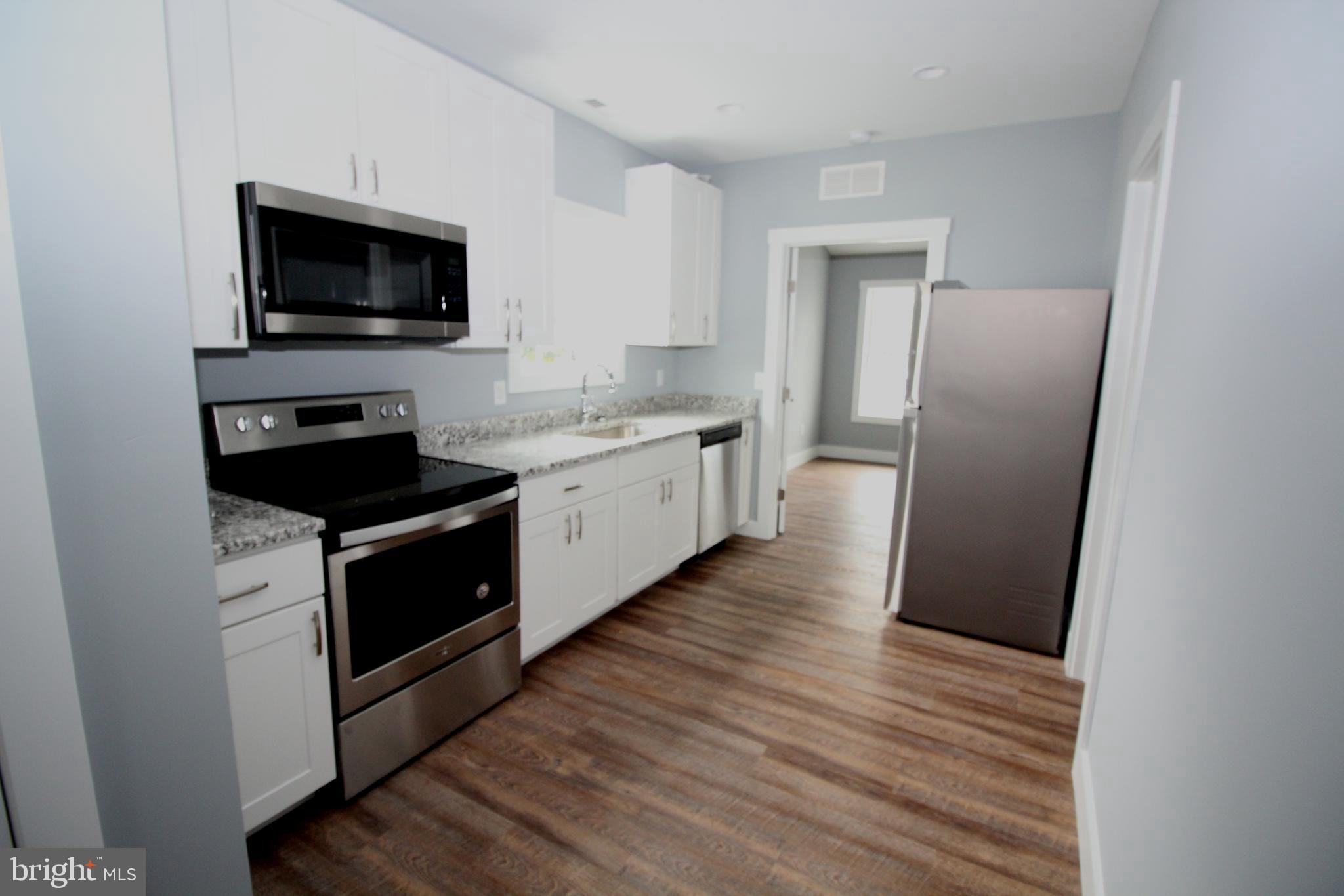 306 Main Street Dover, DE 19901 - Photo 9 of 33 a kitchen with a refrigerator stove and wooden floor