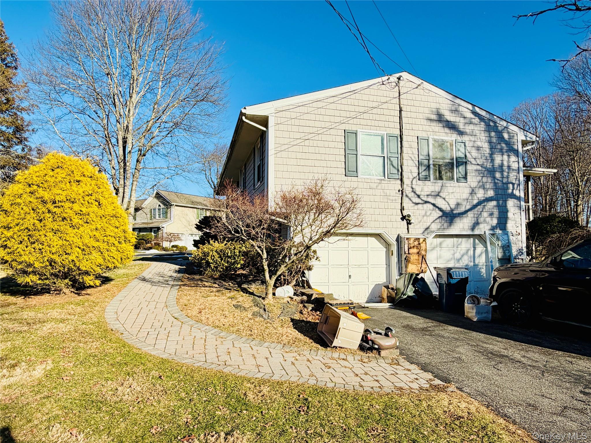 110 Wayacross Road Mahopac, NY 10541 - Photo 5 of 18 View of side of property featuring asphalt driveway, a garage, and a yard