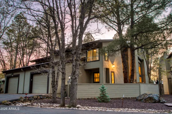 a front view of a house with a tree
