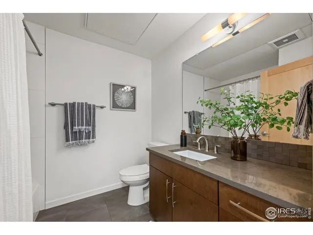 a bathroom with a sink a potted plant and a mirror