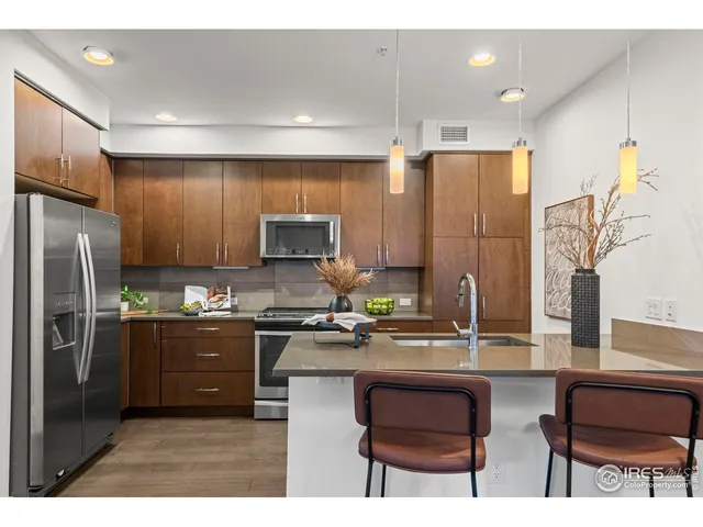 a kitchen with stainless steel appliances a refrigerator a stove a sink cabinets and a refrigerator