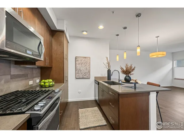 a kitchen with stainless steel appliances granite countertop a stove a sink and a microwave