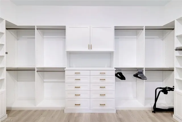 a view of walk in closet with empty racks