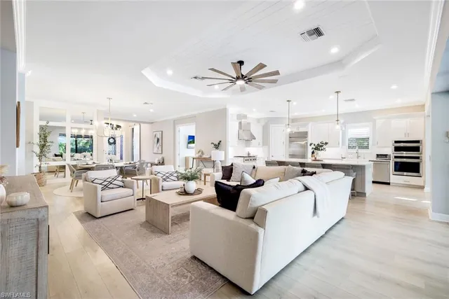 a living room with furniture a ceiling fan and a large window