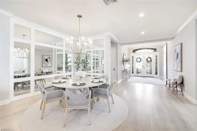 a view of a dining room and livingroom with furniture wooden floor a chandelier