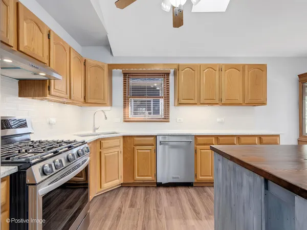 a kitchen with stainless steel appliances granite countertop a stove a sink and a microwave