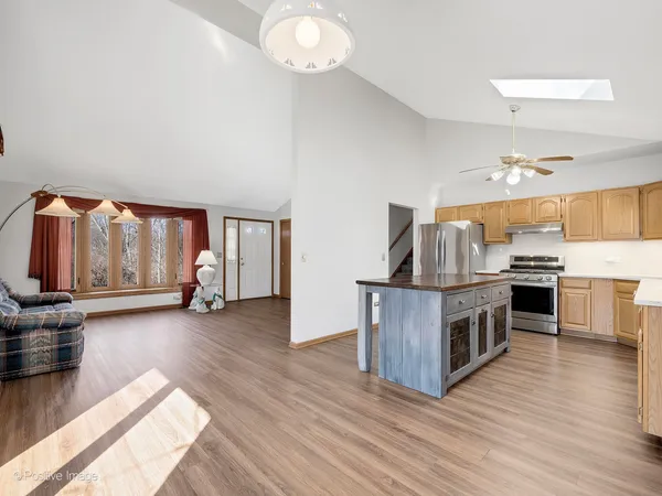 a kitchen with stainless steel appliances wooden floors and stove
