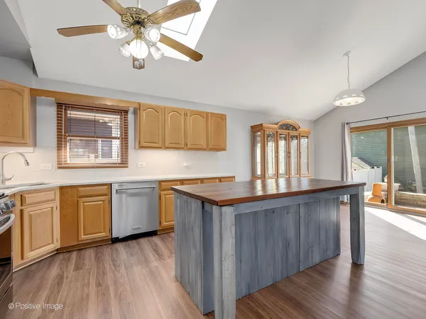 a kitchen with granite countertop wooden floors and white stainless steel appliances