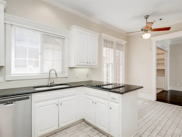 a kitchen with granite countertop a sink cabinets and window