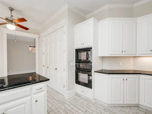 a kitchen with granite countertop white cabinets and appliances