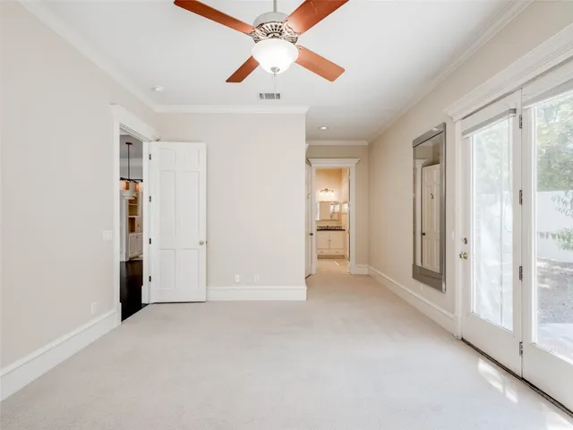 an empty room with closet and a ceiling fan