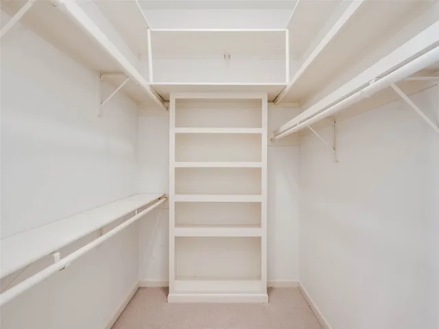 a view of walk in closet with empty racks