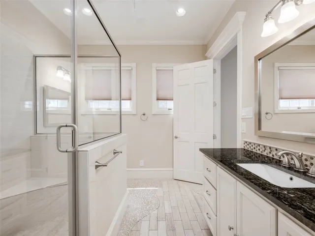 a spacious bathroom with a granite countertop sink a mirror and a shower