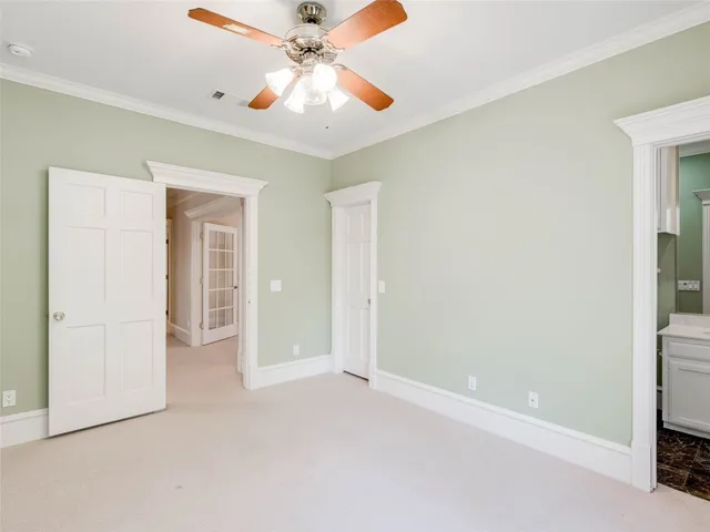 an empty room with closet and a chandelier fan