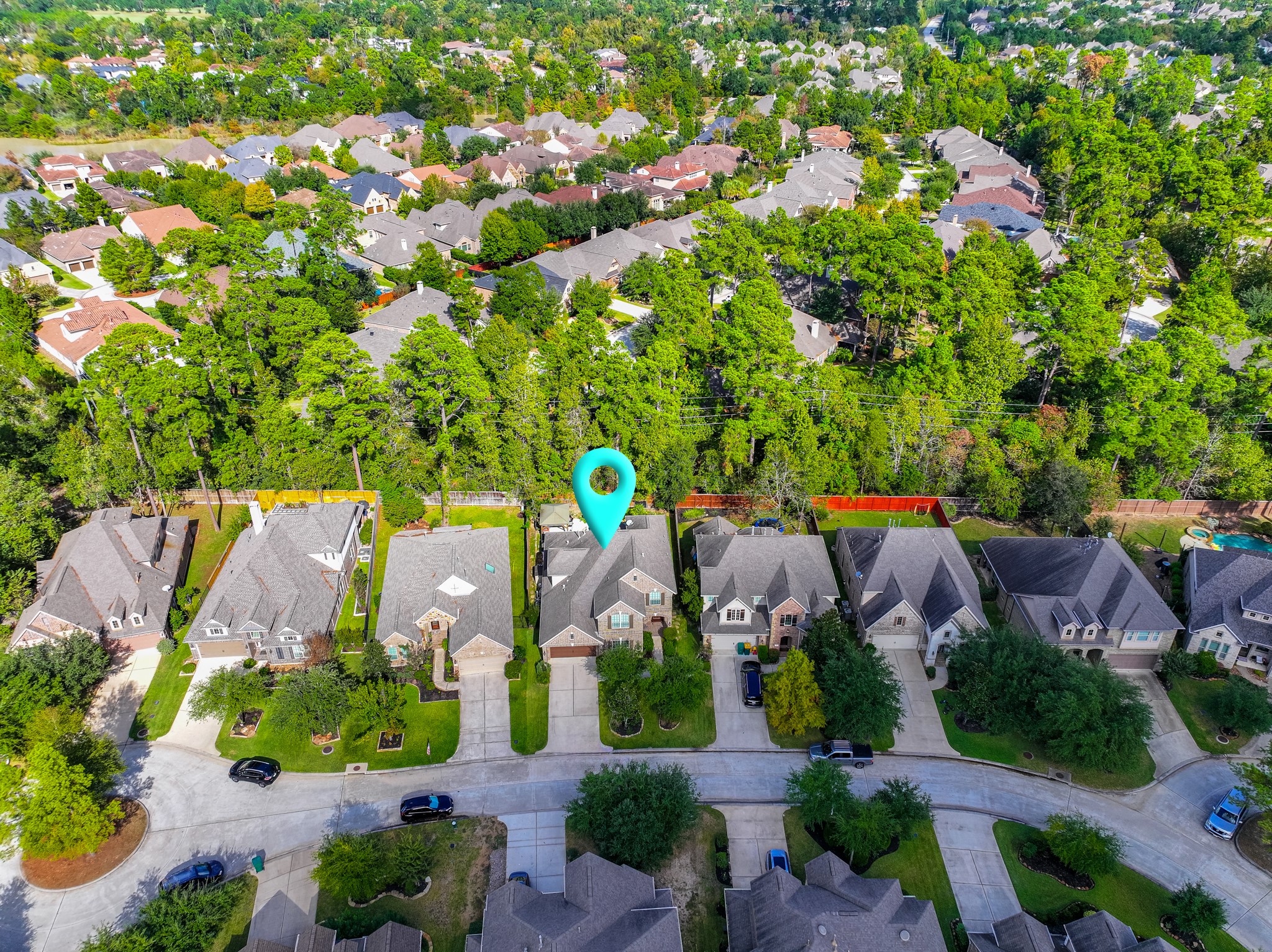 30 Fury Ranch Place The Woodlands, TX 77375 - Photo 5 of 47 This aerial photo showcases a suburban neighborhood with tree-lined streets and well-maintained homes. The highlighted property is a spacious house with a neatly landscaped yard, nestled in a peaceful community surrounded by greenery. Ideal for buyers seeking a serene residential area.