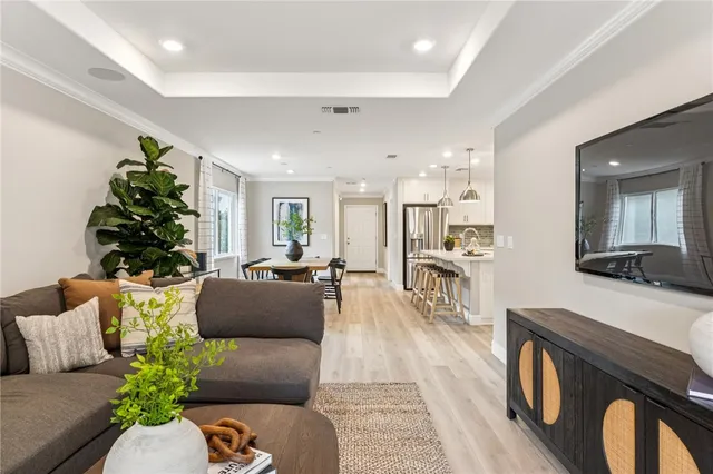 a living room with furniture a chandelier and a wooden floor