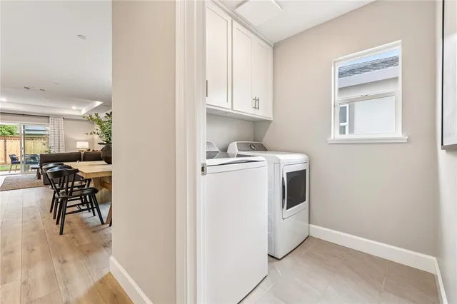 a utility room with cabinets washer and dryer