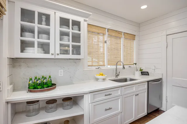 a kitchen with stainless steel appliances white cabinets and a window