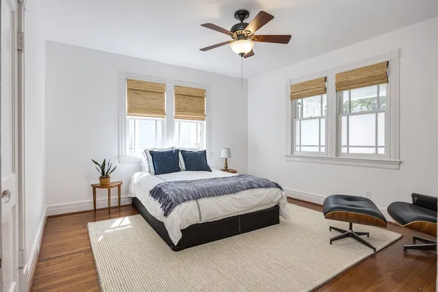 a spacious bedroom with a bed couch and a window