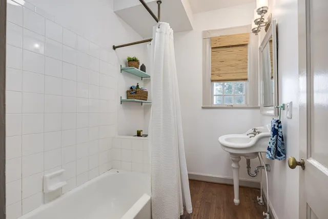 a bathroom with a bathtub shower sink and toilet