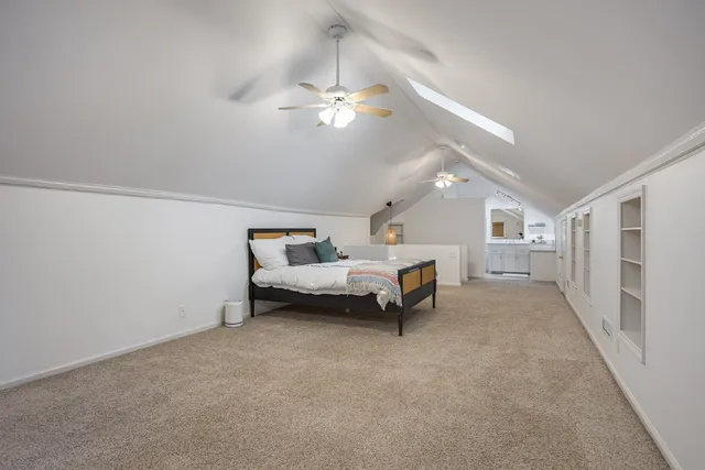 a spacious bedroom with a bed and a chandelier