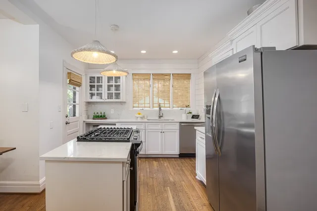 a kitchen with a refrigerator a sink and cabinets