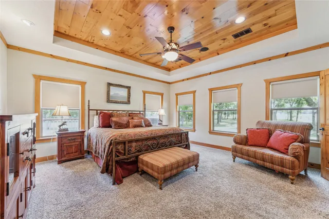 a spacious bedroom with a bed a couch and chandelier