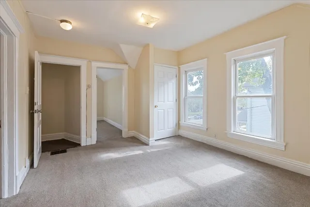 an empty room with windows and closet